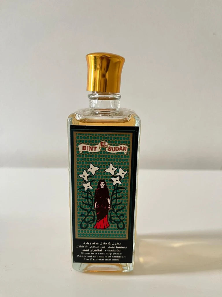 A rectangular glass bottle of El Bint El Sudan perfume with a shiny gold cap and a detailed black label featuring a gothic figure and stars, set against a p Bint El Sudan – Chypre EDT 100mllain light background.