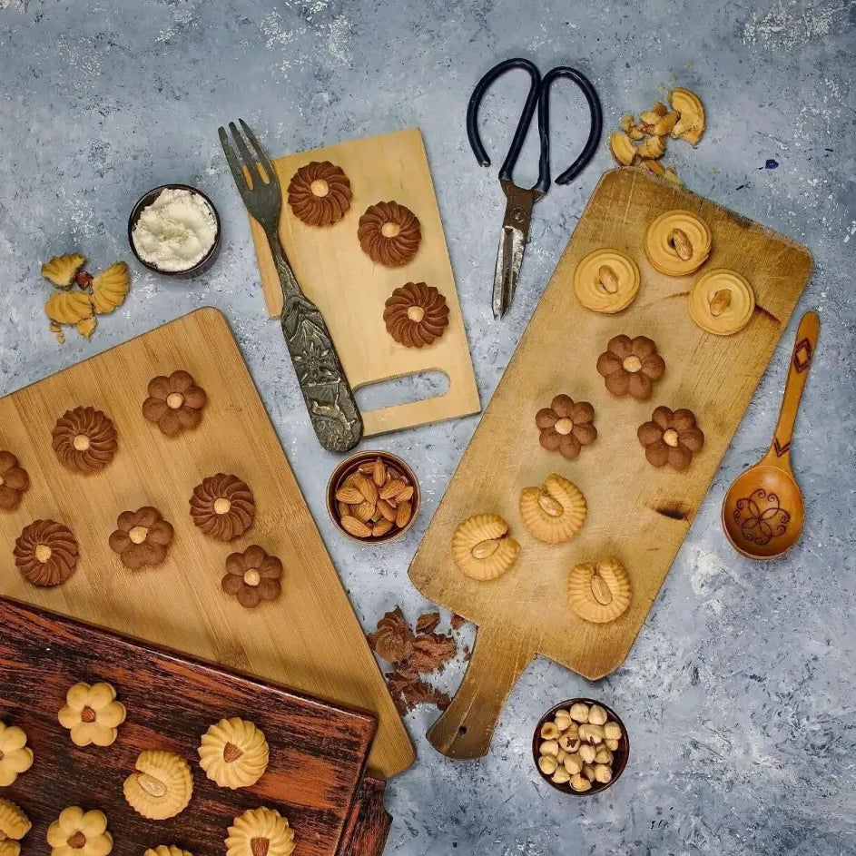 Golden and brown flower-shaped petit four cookies arranged on wooden cutting boards for egyptian cookies el saidy 500g
