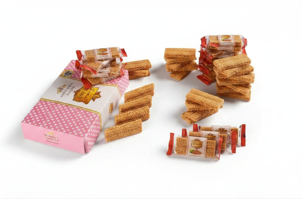 Golden-brown traditional sesame bars in individual wrappers beside a pink polka-dotted box egyptian el saidy 400g
