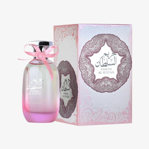 Pink gradient glass hareem al sultan perfume bottle with silver cap and pink ribbon beside ornate ard al zaafaran packaging floral touch
