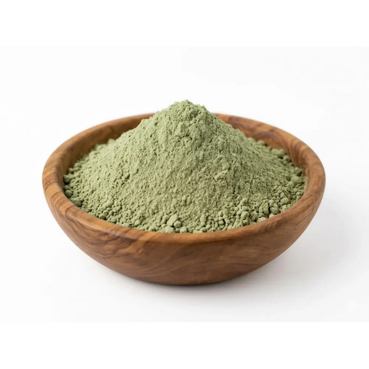 A mound of finely ground green hadrami sidr powder in a rustic wooden bowl for natural hair cleanser and stronger-looking hair