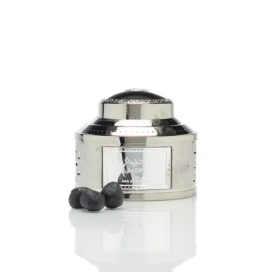 Silver container with black cap and two black spheres on a white background