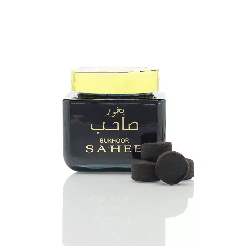 Bukhoor Saheer container with black pieces on a white background