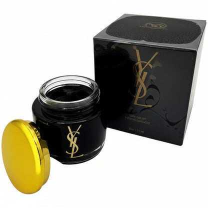 Black candle jar with yellow wick next to a black box on a white background