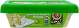Container of halva with a green lid and white base, featuring Arabic text.