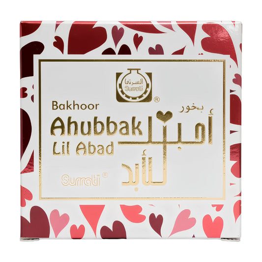 A square white box of Surrati Bakhoor Ahubbak Lil Abad perfume, decorated with a red and pink heart pattern on the borders and a gold foil label in the center.Ahubbak lil Abad Choco Bakhoor 40g – Surrati