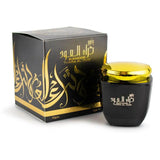 Black and gold perfume bottle with packaging on a white background