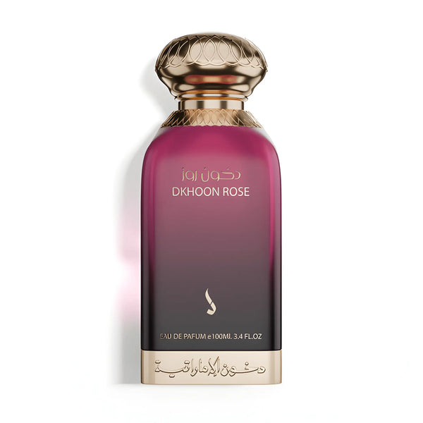 A bottle of Djhouon Rose Eau de Parfum with a dark purple-to-gold gradient body, a textured metallic gold cap, and gold lettering on a white background.Dkhoon Rose – Floral Oriental EDP 100ml – Dkhoon AlEmiratia