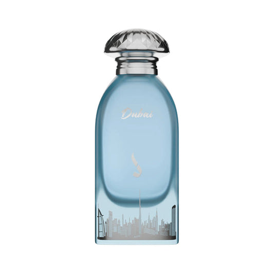 A light blue glass perfume bottle with a silver faceted cap, featuring the word 'Dubai' and a city skyline graphic on the front, set against a plain white background.Dubai Sky – Citrus Woody EDP 100ml – Dkhoon Emirates