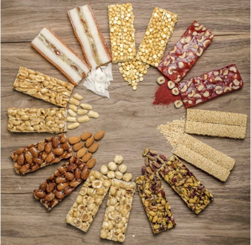 An assortment of colorful nut and seed energy bars arranged in a circular pattern on a rustic wooden background.