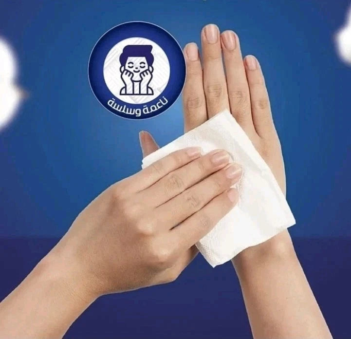 A person's hands holding a white tissue or cotton pad against a blue background, with a circular blue-and-white logo graphic above the hands.  Fine Fluffy white facial tissues 130 sheets 2 ply soft pack green blue packaging