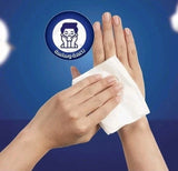 A person's hands holding a white tissue or cotton pad against a blue background, with a circular blue-and-white logo graphic above the hands.  Fine Fluffy white facial tissues 130 sheets 2 ply soft pack green blue packaging