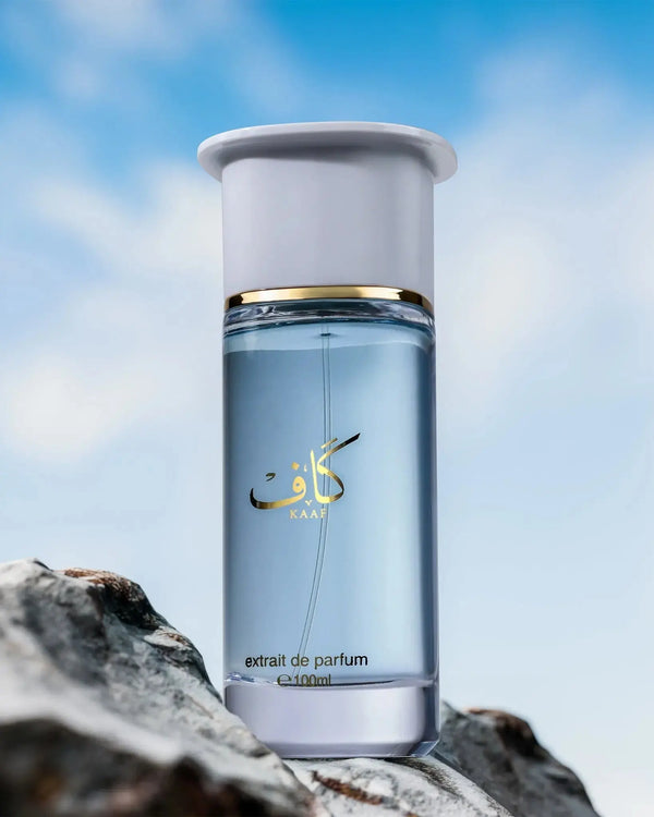 Perfume bottle with blue liquid on a rocky surface against a blue sky