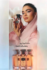 A fashion editorial-style ad featuring a woman in a pink headscarf and pink robe holding a perfume bottle, with additional perfume bottles shown at the bottom and Arabic text on a soft pastel background.