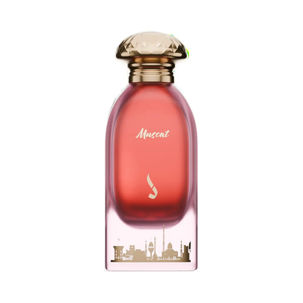 A perfume bottle with a translucent pink-red body, a faceted gold cap, and gold lettering that reads 'Muscot' on a white background.Muscat Sky – Rose Oud Amber EDP 100ml – Dkhoon Emirates