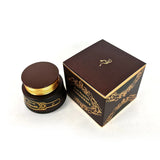 A dark brown cosmetic jar with a gold-rimmed lid sits beside a matching dark brown and gold decorative box on a plain white background.Oud Muattar Munawwara Bakhoor 35g – Khadlaj
