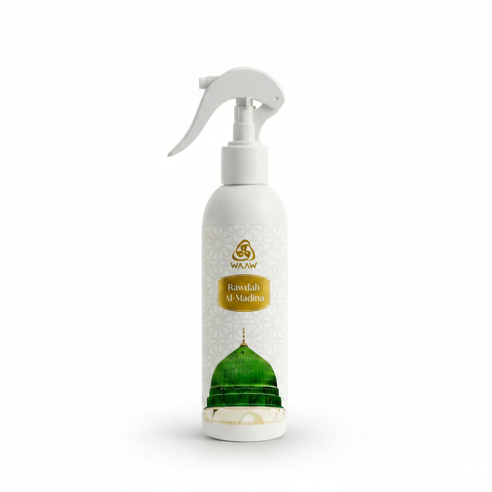 A white spray bottle of WAAW Rawdah Al-Madina fragrance oil, featuring a gold logo and label, and a graphic of a green domed mosque on the lower half.