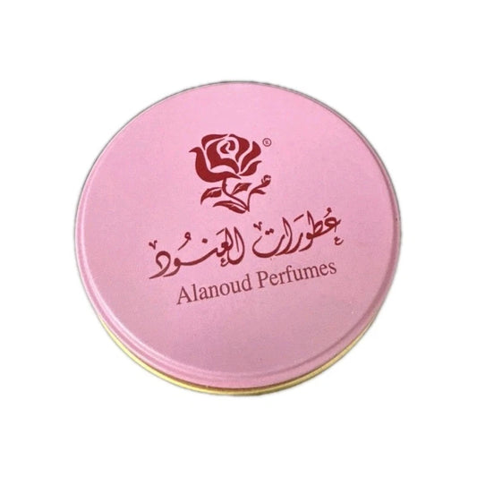 A round pink metal tin for Alanoud Perfumes, featuring a rose logo and Arabic script on the lid, set against a plain white background.