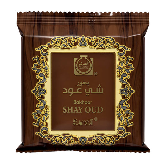 A single sealed pouch of Surati Bakhoor Shay Oud perfume powder, featuring a dark brown wood-grain pattern with an ornate gold and blue decorative border and gold lettering.Bukhoor Shay Oud 40g – Surrati