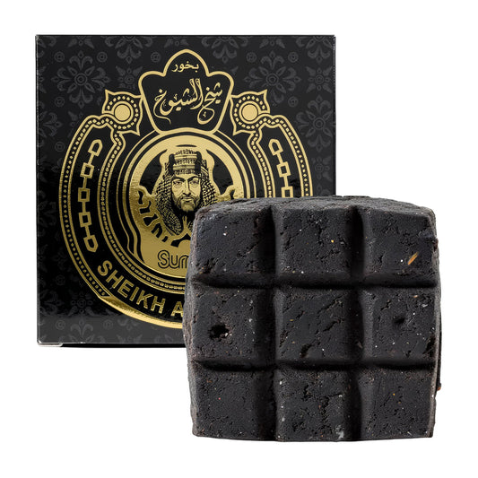 Black soap bar with a decorative box featuring Arabic text and a portrait on a white background