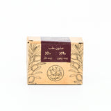 Soap bar with a brown packaging featuring olive tree design and Arabic text on a white background