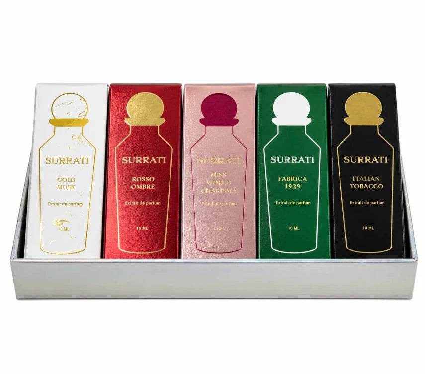 A Surrati perfume gift set containing five 10 ml bottles in their original packaging, arranged in a silver tray. The boxes are white, red, pink, green, and black, each decorated with a gold perfume bottle graphic and gold lettering.