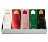 A Surrati perfume gift set containing five 10 ml bottles in their original packaging, arranged in a silver tray. The boxes are white, red, pink, green, and black, each decorated with a gold perfume bottle graphic and gold lettering.