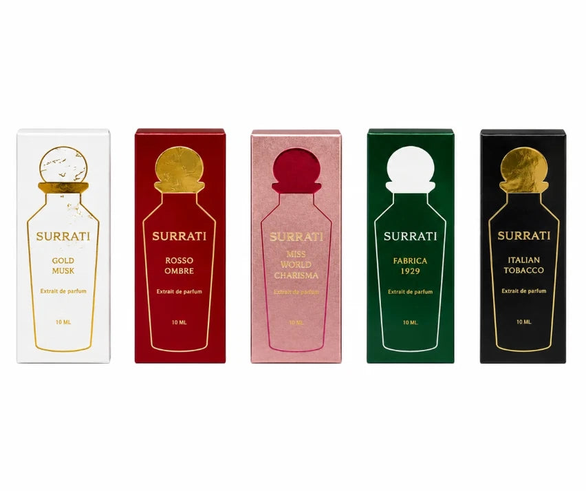 Five Surrati perfume box packages arranged side by side on a white background, each with a different box color and gold bottle illustration: white Gold Musk, red Rosso Ombre, pink Miss Vivido Chiabrina, green Fabbrica 1929, and black Italian Tobacco.