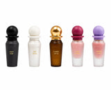 Five Surratt perfume bottles lined up on a white background, featuring different colored spherical caps and frosted glass bodies in black, white, amber brown, pink, and light purple. Surrati Mini Collection 2 -5X10ml EDP-S Gift Set