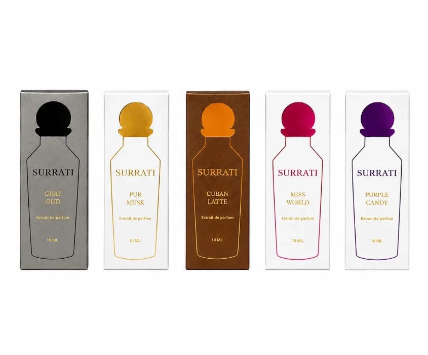 Five Surrati perfume boxes arranged in a row on a white background, each with a different colored cap and label: gray with black, white with gold, brown with orange, white with pink, and white with purple.