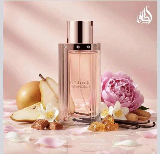 Perfume bottle with pear, flowers, and vanilla beans on a soft pink background