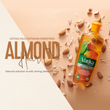 Vatika Almond Hair Oil bottle displayed on a peach background with scattered almonds and coconut pieces, alongside large text reading 'VATIKA MULTIVITAMIN ENRICHED ALMOND Hair Oil'.