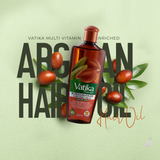 A bottle of Vatika Moroccan Argan Hair Oil is centered against a light sage green background, surrounded by argan nuts, leaves, and large dark text. The product bottle is amber-brown with a red cap and a green-and-white label.