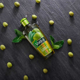 Vatika olive oil bottle with olives and leaves on a dark surface