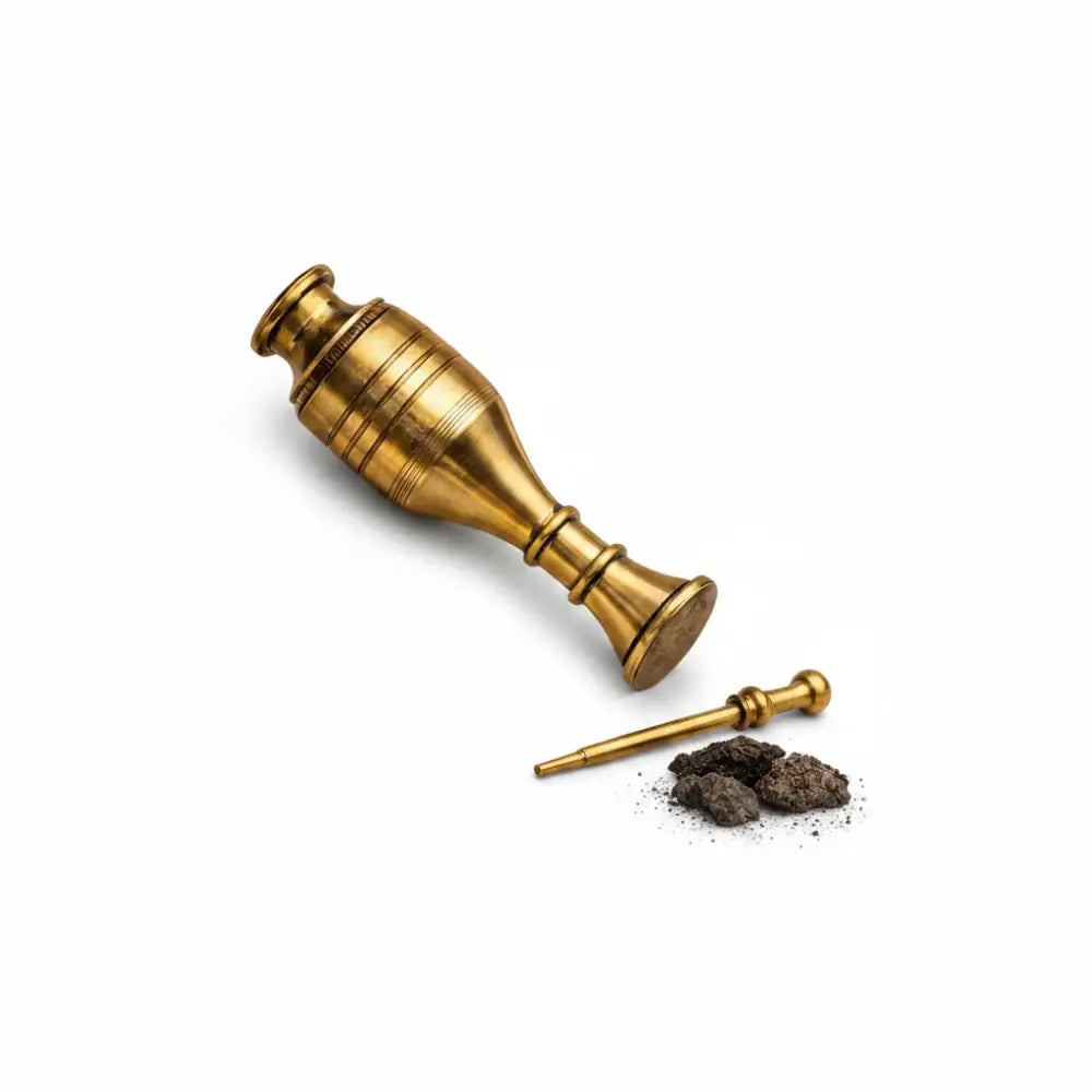 Brass mortar and pestle with ground substance on a white background