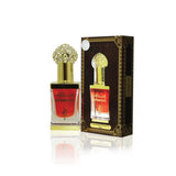 Perfume bottle with gold cap and red label next to its packaging on a white background