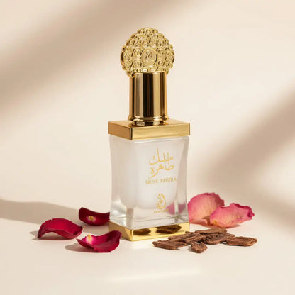 A luxurious gold-toned square glass bottle with an ornate cap of arabiyat musk tahira concentrated perfume oil unisex attar