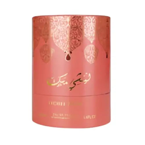 A cylindrical coral-colored arabiyat prestige perfume bottle with gold foil and arabic script featuring lychee musk
