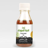 A clear glass bottle of amber black seed oil nigella sativa un roasted with halal certified and organic labels