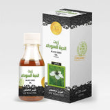 A clear glass bottle of habashi black seed oil 125ml amber nigella sativa natural halal certified al helal label