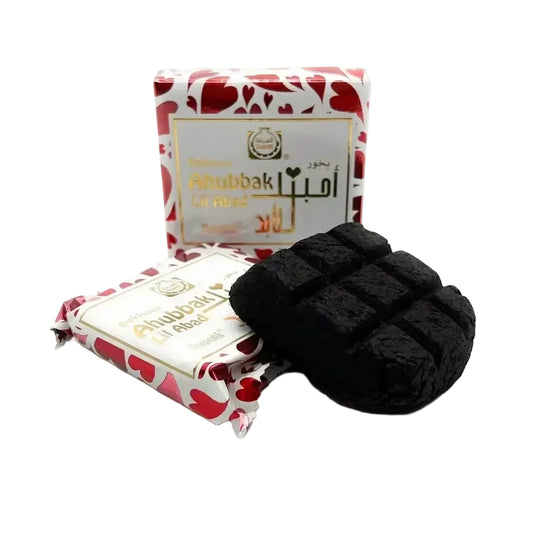 Black cube-shaped charcoal briquette with textured surface for bukhoor ahubbak lil abad 40g by surrati