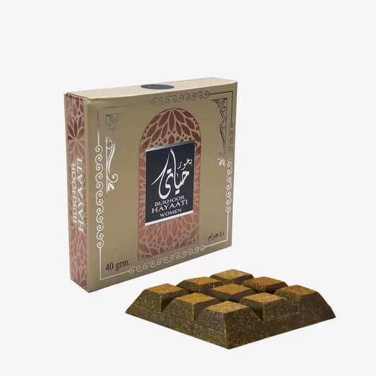 A rectangular gold-colored block of bukhoor hayaati women incense with textured surfaces by ard al zaafaran 40g
