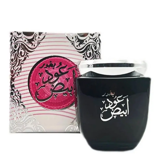 Black perfume bottle with Arabic text next to a decorative box on a white background