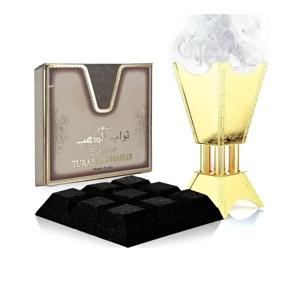 Golden incense burner with intricate detailing and matching turab al dahab box beside black charcoal cubes bukhoor turab ard al zaafaran