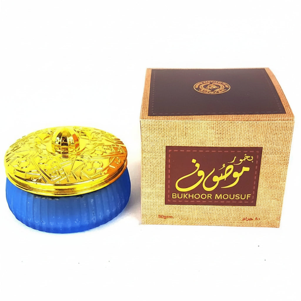 Blue container with gold lid and 'Bukhoor Mousuf' packaging on a white background