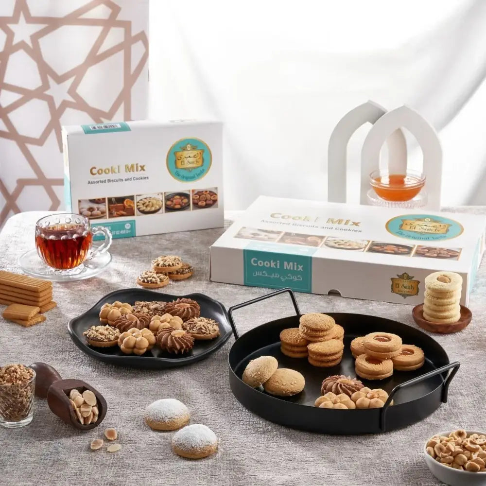 Assorted golden brown and chocolate middle eastern cookies on black trays from el saidy egyptian cookie mix 1150g