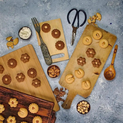 Golden and brown flower-shaped petit four cookies arranged on wooden cutting boards for egyptian cookies el saidy 500g
