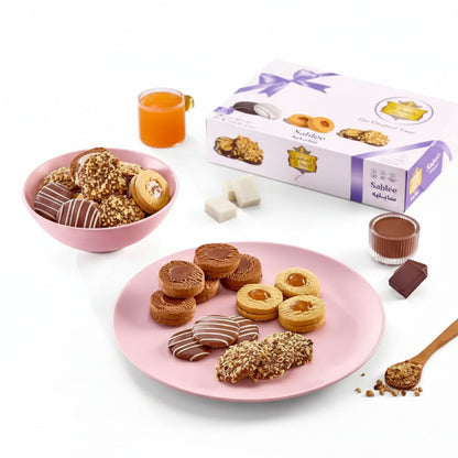 Pink plate holding assorted halal certified Egyptian cookies sablée with chocolate caramel and crushed nuts toppings