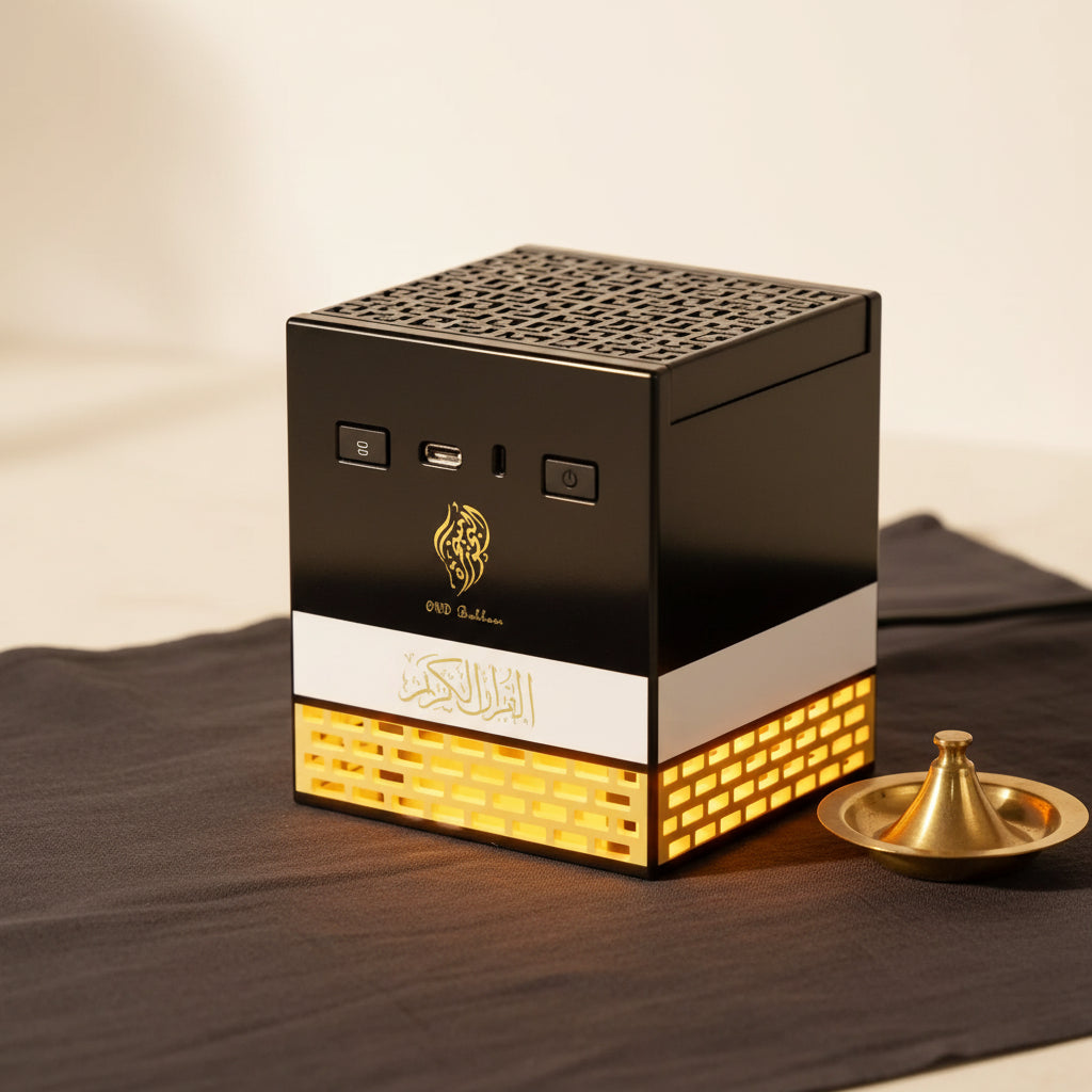 Black and gold cube-shaped electric quran speaker with perforated top, white band, and illuminated golden brick base