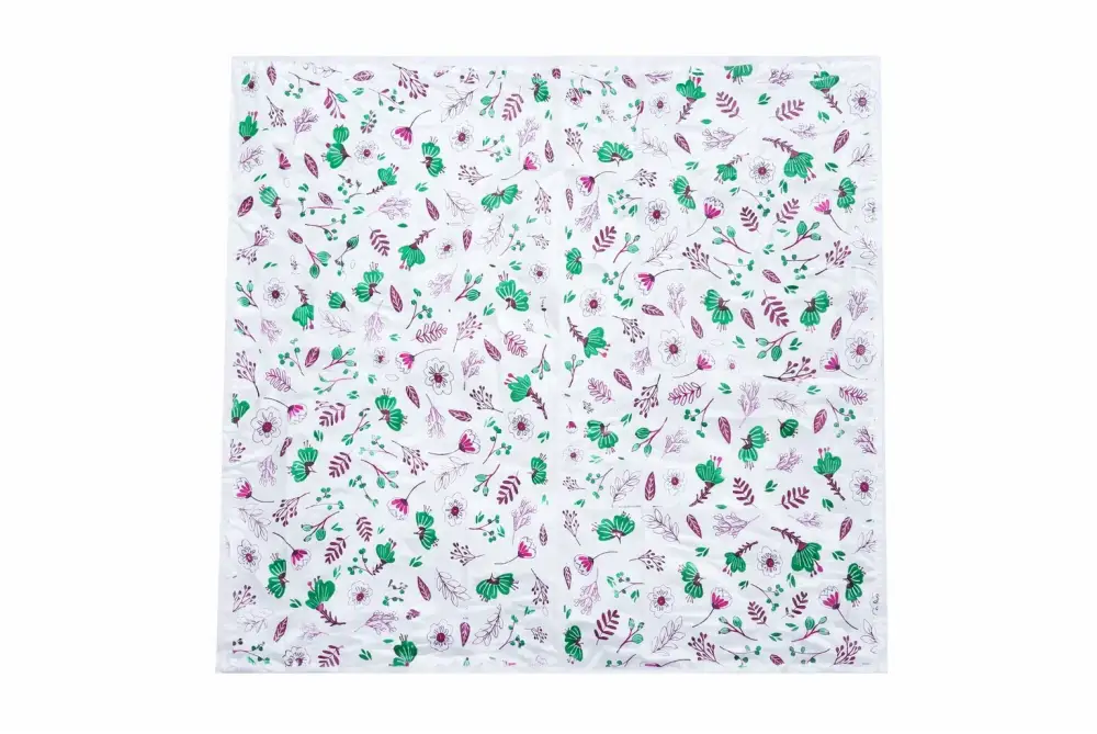 White square scarf with green and pink floral motifs shown with elite disposable table sheets sufra roll for food serving